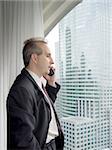 Businessman talking on the phone by the window