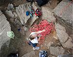 A female climber belaying - viewed from above.  A shallow depth of field is used to isolate the climber - with focus on the eyes and head.