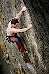 A male rock climber on a steep rock face.