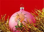 pink christmas bauble with golden tinsel