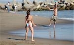Couple playing frisbee on the beach