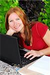 Happy mature woman working on portable computer at home, small business owner