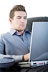 Male comfortably sitting in a sofa using a laptop