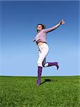 Happy woman running on grass