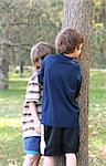 Boys Having Fun Peeking Around  A Tree