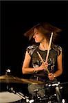 shot of woman drummer playing over black backdrop