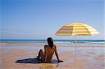 a summer scenic with a yellow umbrella at the beach