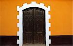 Black door, Yellow Wall on a colonial style building in Puno, Peru