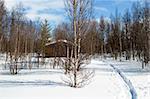 A cabin in the forest on a winter landscape.