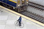 A commuter waits with her bike for the arriving train.