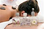 Assorted decorative scented products in focus by a woman relaxing at a day spa