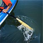 African American male arm paddling kayak.