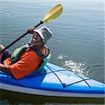 African American middle-aged man smiling at viewer in kayak.
