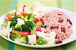 Caribbean style rice cooked with red kidney beans served with fresh garden vegetables. Shallow DOF.
