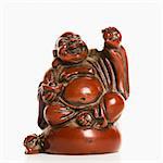 Happy laughing Buddha figurine with hand raised in blessing on white background.