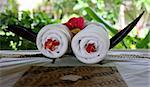 White rolled up towel with red flowers