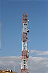 communications antena tower full of dishes with sky background