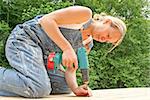 An attractive woman renovates the deck of her new home.