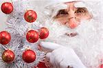 Portrait of Santa Claus with christmas tree and red bulbs