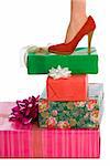 Female Leg in red shoe standing on stack of wrapped gifts