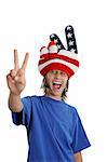 A teen boy in a USA patriotic hat giving a peace sign and making a funny face.