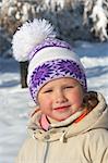 Portrait of small girl in winter snow covered city park