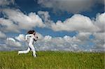 Beautiful woman running on a green meadow