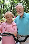 A happy, active senior couple going for a bike ride.