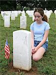 a girl in a military graveyard, mourning a fallen soldier