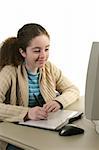 A teen girl drawing on a computer graphics tablet.