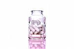 bottle of pills isolated on white background, with a pink glow