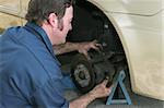 A mechanic adjusting front disc brakes.