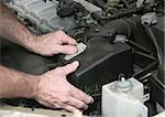An auto mechanic removing the cover from a car air filter.