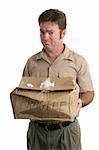 A delivery man holding out a smashed package and looking very sorry.  Isolated.