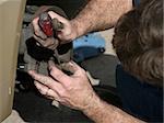 A mechanic opening the brake housing on a car to check the brake pads.