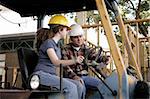 A construction foreman instructing a new worker on driving heavy equipment. Focus on the foreman.