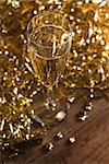 Champagne flute with golden ribbons - shallow dof, focus on the bubbles.