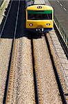 Oncoming suburban train on railway tracks.