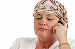 A woman, bald from chemotherapy, having a serious cell phone conversation.