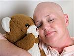 A medical patient cuddling with a teddy bear for comfort.