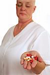 A medical patient holding a handful of pills.  The focus is on the pills.