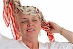 A beautiful chemotherapy patient begins removing the scarf from her head.  Third in a sequence.