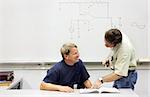 An adult technical college student smiling at his helpful teacher.