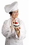 A chef holding a strawberry cheesecake tart and wagging her finger NO.  Isolated on white.