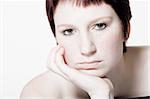 Studio portrait of a young woman with short hair looking uninterested