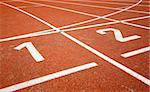 first two numbers of a racetrack, on red tarmac, for runners