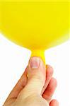 Ein gelber Ballon in einer Hand gehalten.  Isoliert auf weiss mit Beschneidungspfad.