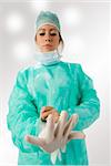 an assistant putting on her gloves before the operation
