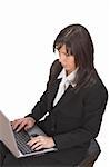 Young brunette businesswoman working on a laptop against a white background