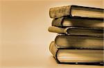 Sepia toned image of stacked books.